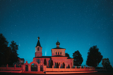 Korma Village, Dobrush District, Belarus. Comet Neowise C2020F3 And Meteor In Night Starry Sky Above St. John The Korma Convent Church In Korma Village. Famous Orthodox Church And Historic Heritage