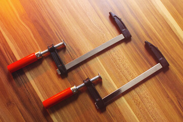 Two wood clamps on a wooden table.
