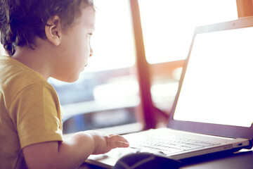 Little child using laptop at home