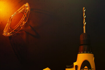 Close-up of an electric screwdriver on a dirty dark background.