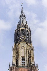 Fototapeta na wymiar View of XV century Belfry of New Church (Nieuwe Kerk, 1396 - 1496) on central Market square in Delft, Holland. New Church, with 108,5 m church tower - second highest church in the Netherlands.
