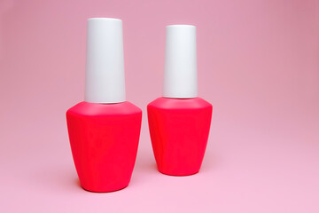 Bottle of nail Polish on a pink background.