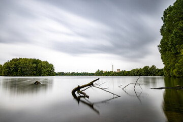 Baum liegt im See. Wasser glatt in Petershagen Kraftwerk Panorama