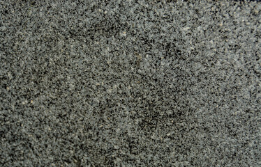 a porous texture consisting of small stones of gray white and black color of different sizes. blurred focus
