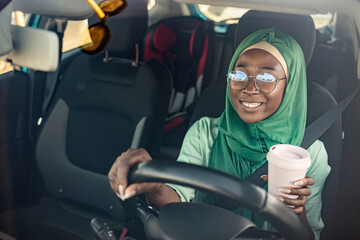  Beautiful muslim woman with toothy smile driving car. Portrait of a Middle Eastern woman driving a...