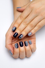 Fototapeta premium Gray-black manicure with silver stripes and drops on short square nails, close-up on a white background. Gray-blue nails.