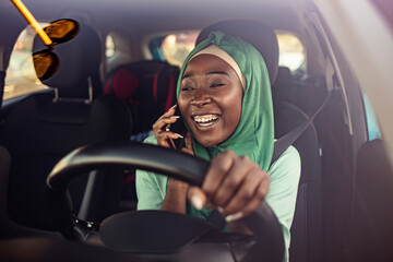 Muslim businesswoman on a business trip, driving a car and talking with smartphone. miling black muslim woman driving her vehicle. Happy muslim woman driving car