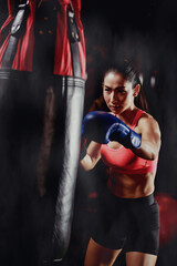 asian woman training with punching bag