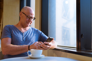 Senior handsome Scandinavian man relaxing inside the coffee shop