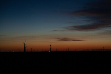 Fototapeta premium Wind turbines on a farm at dawn