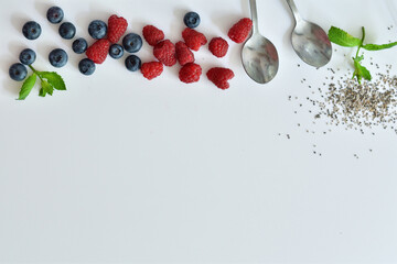 Summer layout made with juicy ripe berries of blueberries and raspberries on a white background. Summer mood.