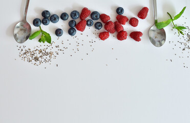 Summer layout made with juicy ripe berries of blueberries and raspberries on a white background. Summer mood.