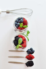 Summer layout made with juicy ripe berries of blueberries and raspberries on a white background. Summer mood.