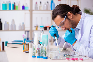 Young male chemist working in the lab