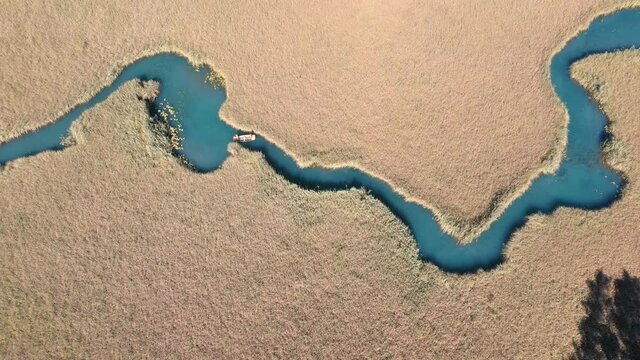 River with Rowing Boat leading through Reed, Nature Reserve, Lake Faak, Austria  - Faaker See