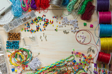 the process of making handmade bracelets, bright jewelry with beads made of waxed cord