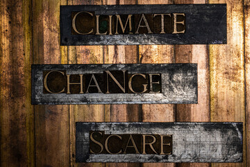 Climate Change Scare text formed with real authentic typeset letters on vintage textured silver grunge copper and gold background