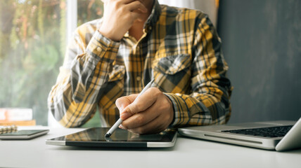 Business people use tablets and hold credit cards as an online shopping concept With a calculator and a book placed on the table