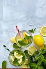 Refreshing drinks for summer, cold sweet and sour lemonade juice in the glasses with sliced fresh lemons. Refreshing summer drink. Traditional lemonade with lemon, mint and ice. Selective focus