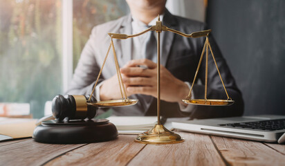 Justice and law concept.Male judge in a courtroom with the gavel, working with, computer and...