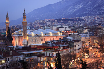 Historical Grand Mosque (Ulucami), Uludag with snow and Bursa city night landscape.