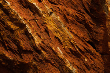 A closeup surface of red lava textured rocks and stone of red, brown, orange and grey color