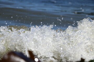 Close up of a wave erupting in ecstasy as it blows itself all over the curvy rocks which it has been gently massaging until climax 