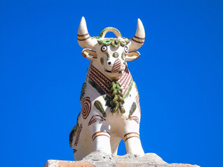 Typical Peruvian bull figurine on top of a roof. These figurines are also known as Torito de Pucara.