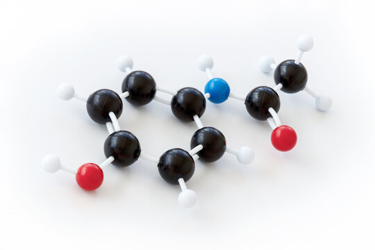Plastic ball-and-stick model of a paracetamol molecule shown with kekule structure on a white background. Paracetamol, also called acetaminophen or apap is a common painkiller.