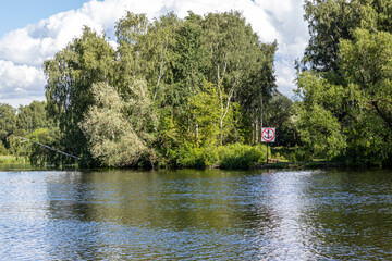 Obraz premium Navigational sign on the bank of the canal prohibiting the stopping of river vessels. Sign for skippers. The anchor is not to throw the mooring of boats is prohibited. Sign on the picturesque Bank.