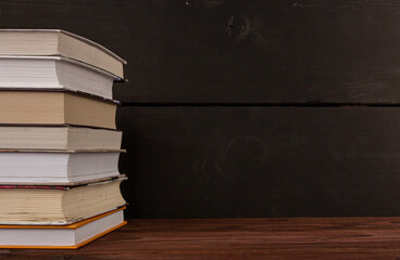 Close-up stack of books on a wooden table with space for text. Books in the library on the table....