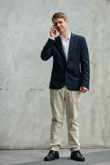 Full body shot of young handsome businessman in suit outdoors