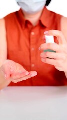 A vertical photo of a young woman who is using a gel bottle