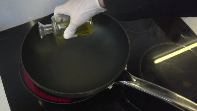hombre pone aceite en la sart&eacute;n a c&aacute;mara lenta