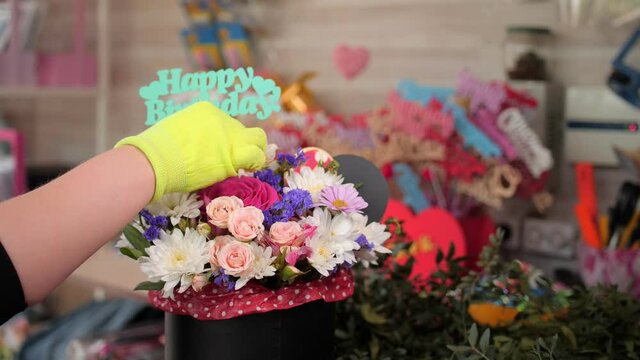 florist puts words Happy Birthday into fresh bouquet in shop