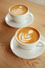Breakfast in the cafe. Beautiful white mug with cappuccino or latte coffee on a wooden table. View from above. 