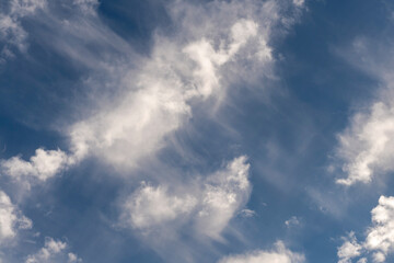 White clouds all over the sky with a blue background of daylight sky. Natural composition of the sky. Design element, background.