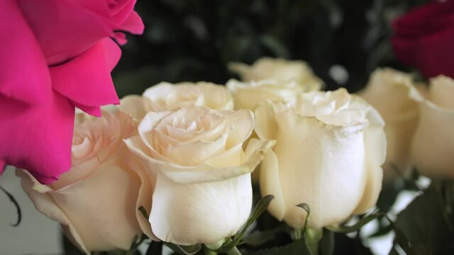 motion to white rose bouquet on dark background in shop