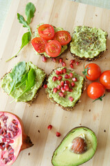 Delicious and healthy guacamole sandwiches on a bamboo board 