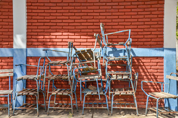 Pile of broken chairs outside a classroom in a public school class in Nicaragua with a red brick...