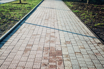 Nested pavers of various colors, around the grass is green, chic garden