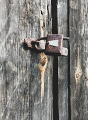 old rusty padlock on a wooden door