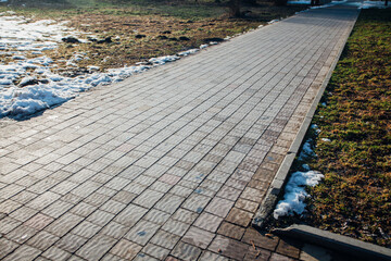 Nested pavers of various colors, around the grass is green, chic garden