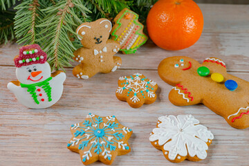 Gingerbread cookie near christmas tree on wooden background. New Year and Christmas composition