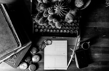 vintage desk with typewriter, ink pen, pocket watch, old glasses and vintage textured blank writing postcard