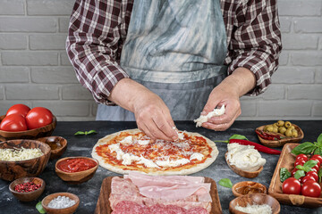 Obraz na płótnie Canvas Pizza preparation with chef hands. Pizza making process decorating pizza