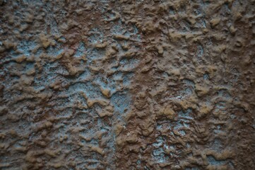 Still-life. Photo of the wall surface with streaks and clumps of plaster. In Dark Reds and bright Blues.