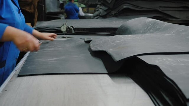 Industrial worker cuts rubber sheet, sealing rubber and gasket production