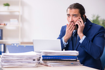 Fototapeta premium Young male employee unhappy with excessive work