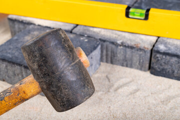 Laying paving stones on sand. Minor paving work in a home environment.